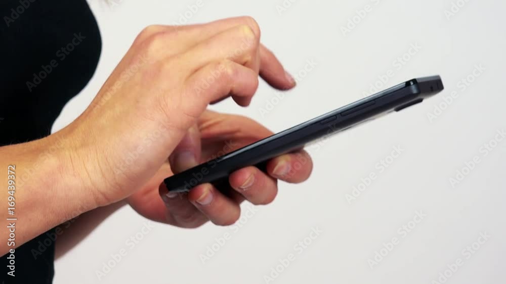 A woman works on a smartphone - closeup - white screen studio A woman works on a smartphone - closeup - white screen studio