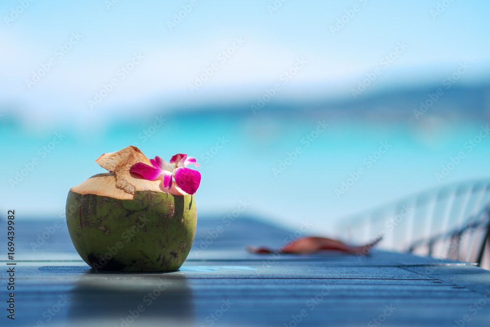 Fresh coconut water on the table on sea background. Fresh coconut water on the table on sea background.