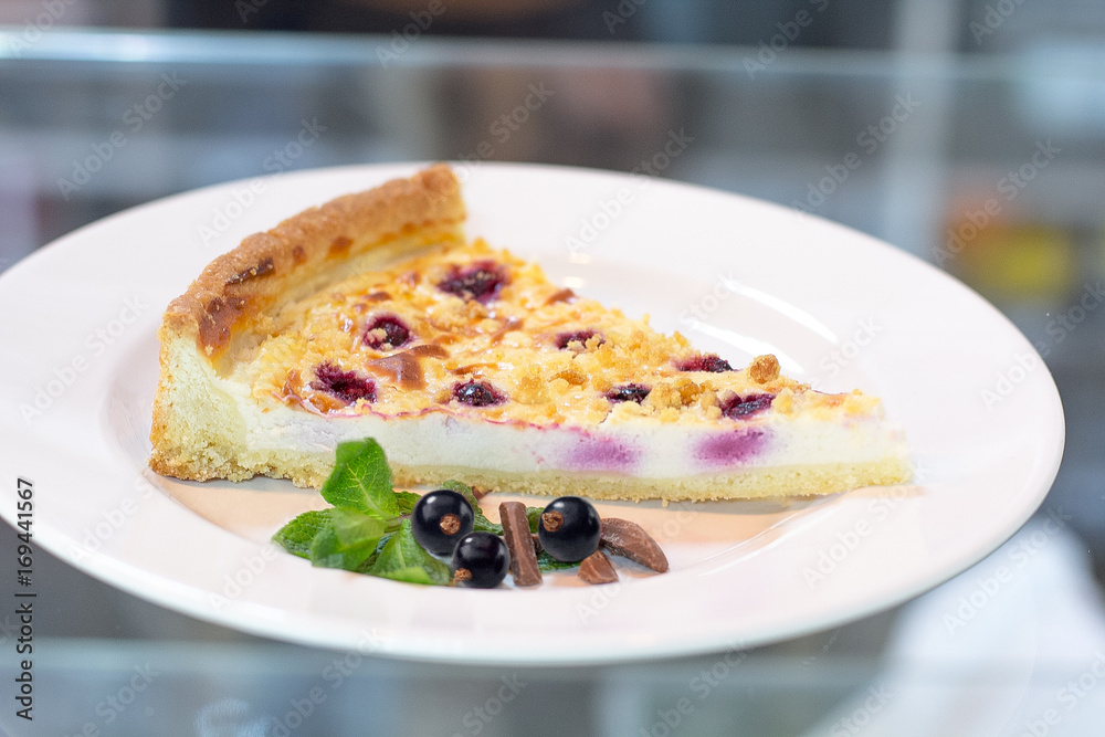 Cheesecake with black currant on a white plate