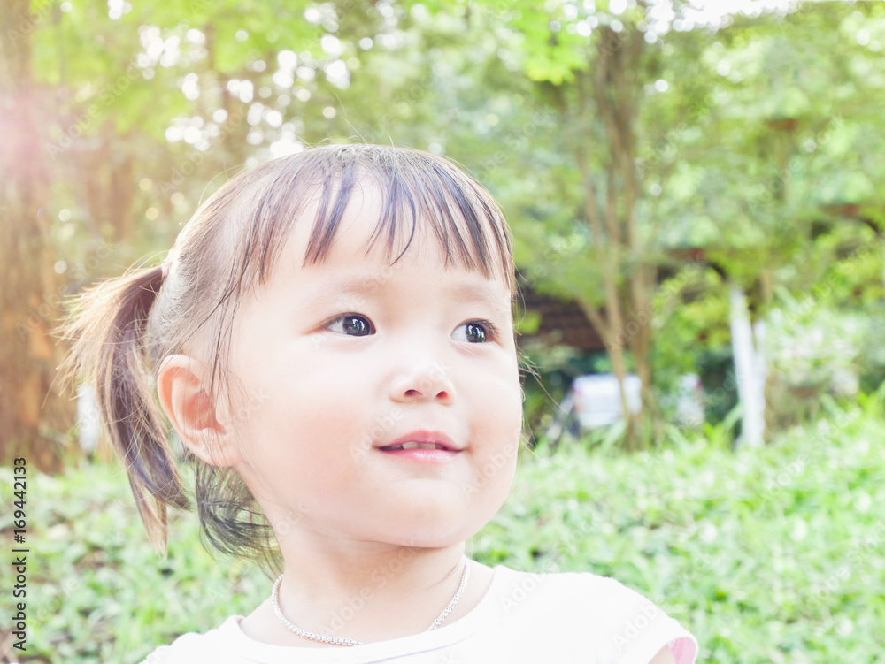 portrait of little girl playing in the green garden with warm tone and soft focus ,asian baby portrait of little girl playing in the green garden with warm tone and soft focus ,asian baby