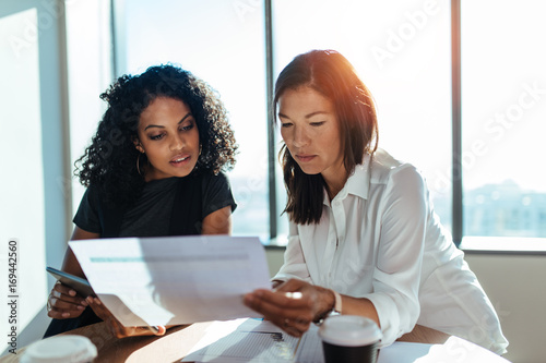 Business partners discussing business ideas looking at paper.