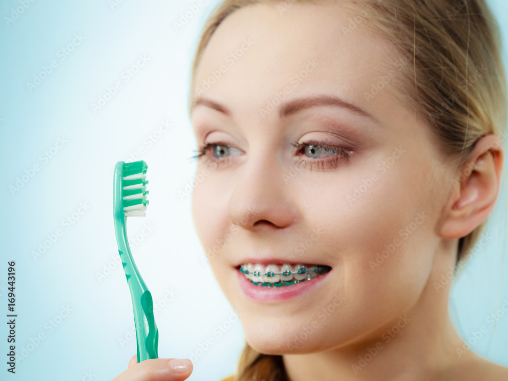 Woman with teeth braces using brush Woman with teeth braces using brush