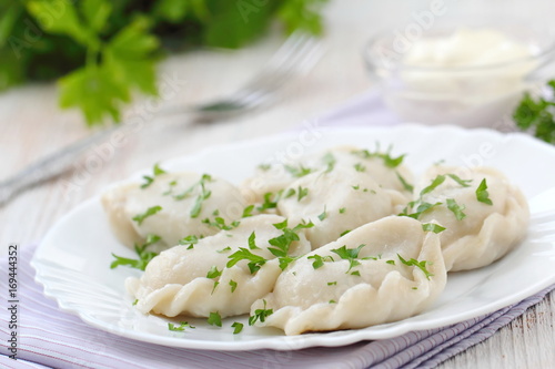 Dumplings with sour cream and fresh parsley