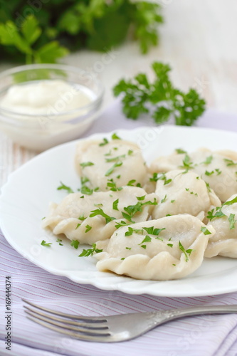 Dumplings with sour cream and fresh parsley