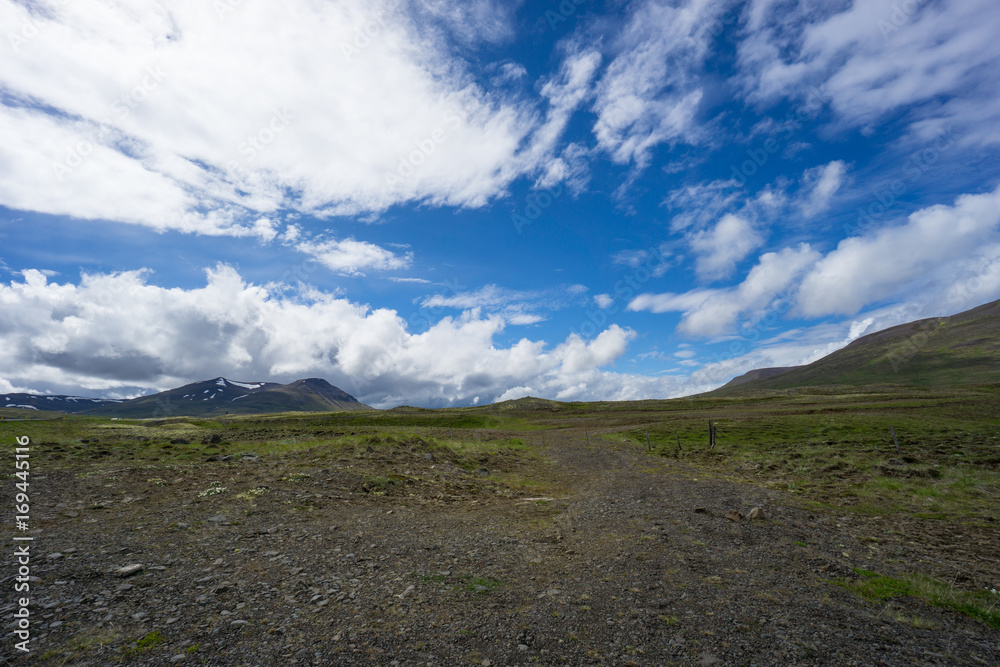 Iceland - Bright sunny day with some clouds in wide mountainous landscape