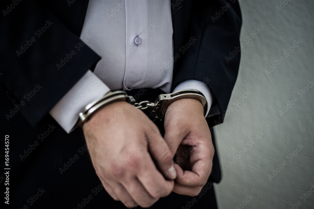 Φωτογραφία A businessman caught with handcuffs on his stomach for corruption and stealing fraud and bribery of banks in a million dollars