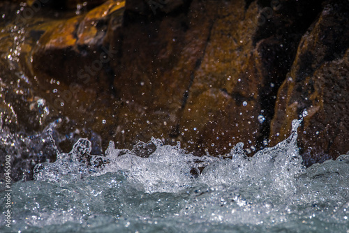 Foto Splashes and drops of river water against a stone background