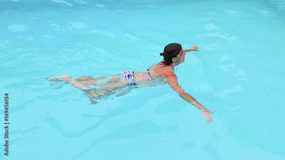 fit woman swimming in home house pool in summer