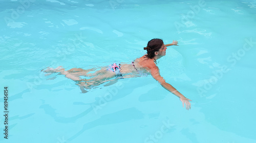 fit woman swimming in home house pool in summer