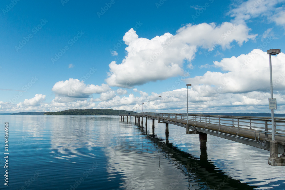 Fishing pier with puffy clouds