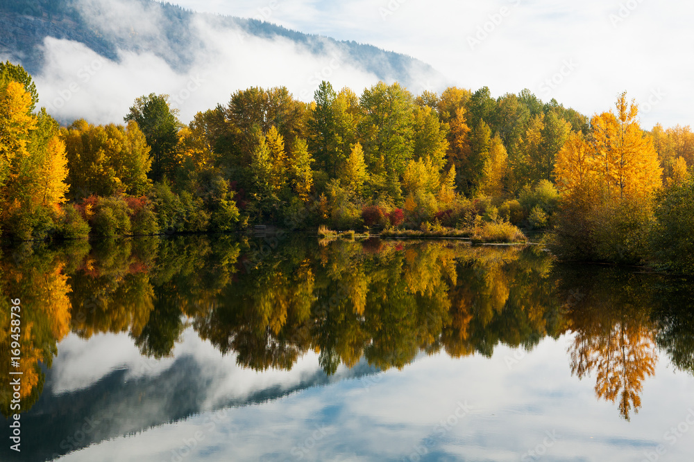 Fall foliage reflected in calm water Fall foliage reflected in calm water