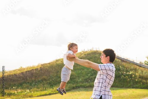 Father and son playing on the field at the day time. People having fun outdoors. Concept of friendly family