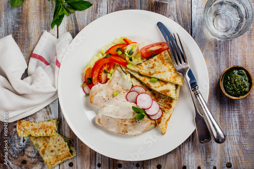 Turkey cutlets served with vegetables, pita bread with pesto and cream sauce. Copy space