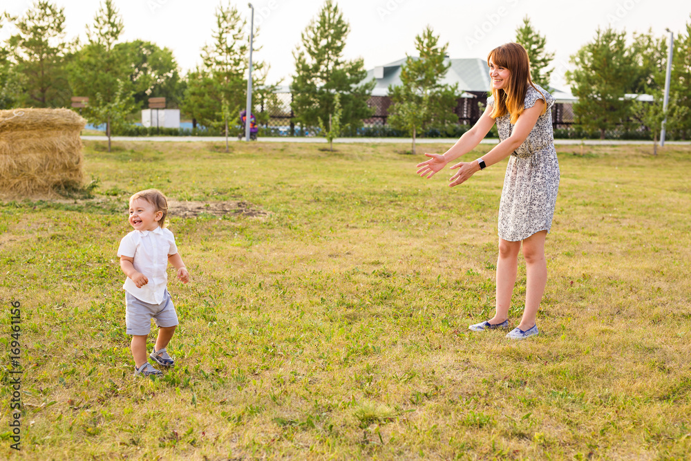 Fototapeta premium Cute cheerful child with mother play outdoors in park