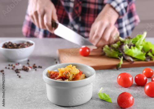 Woman cooking tasty dinner in kitchen