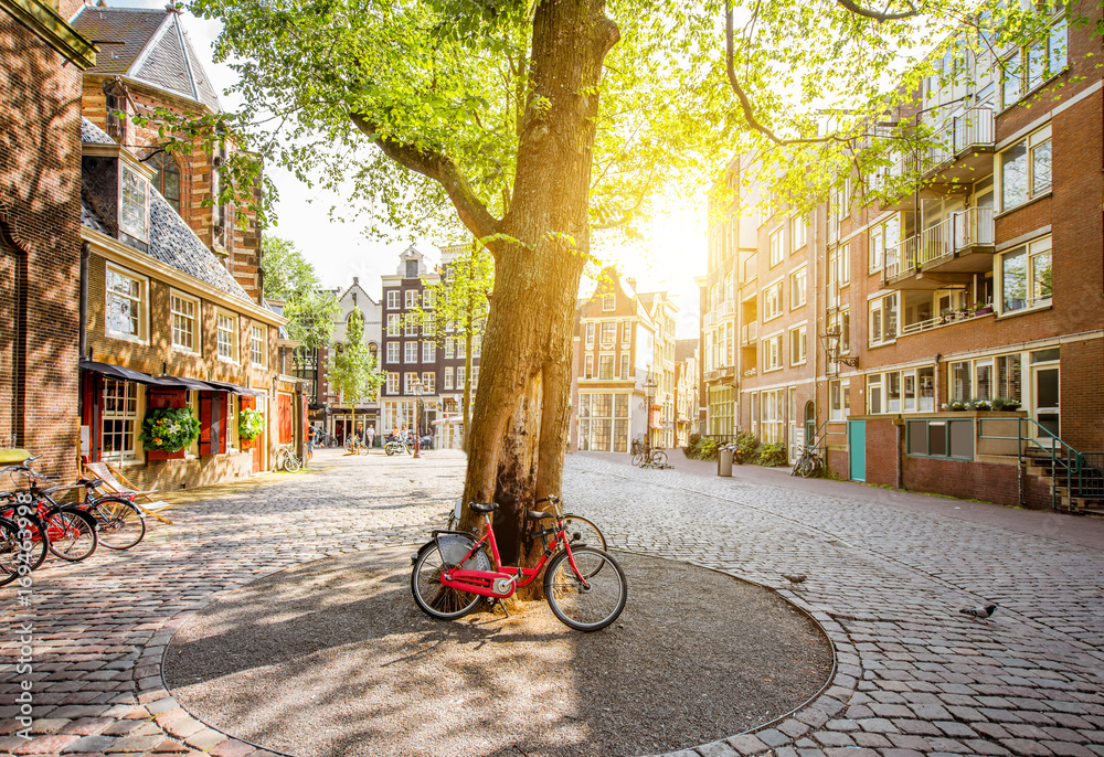 Fototapeta premium Morning view on the square with beautiful buildings near the Old Church in Amsterdam city