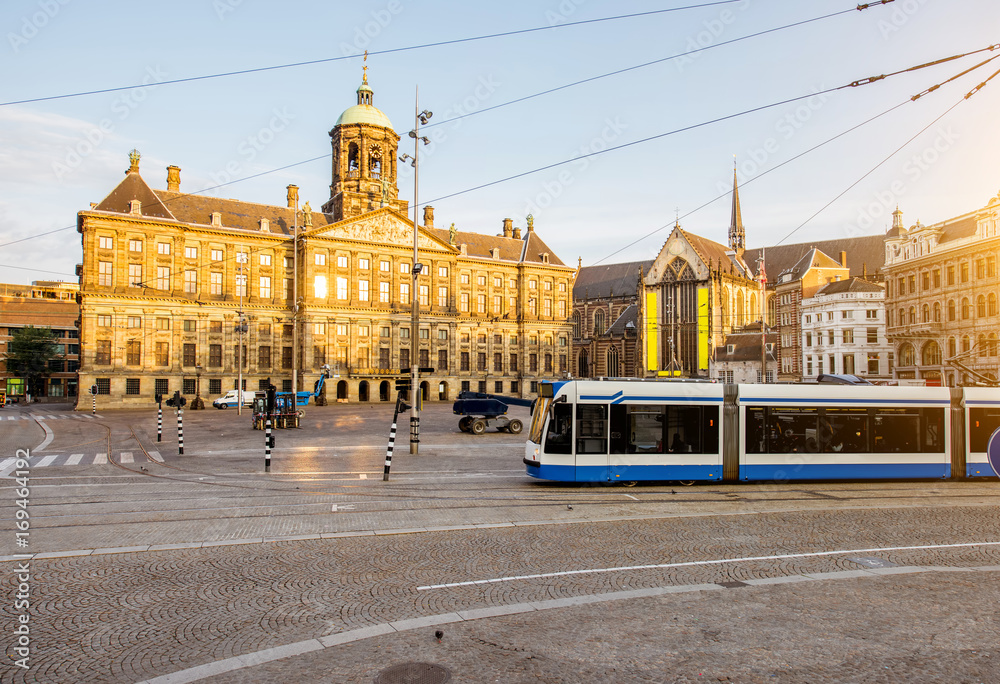Morning view on the Dam square with Royal palace and tram in Amsterdam city during the sunny weather