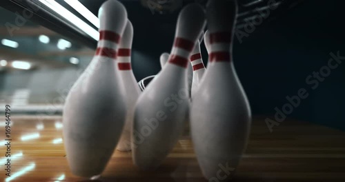 Bowling strike, bowling ball knocks down bowling pins in slow motion photo