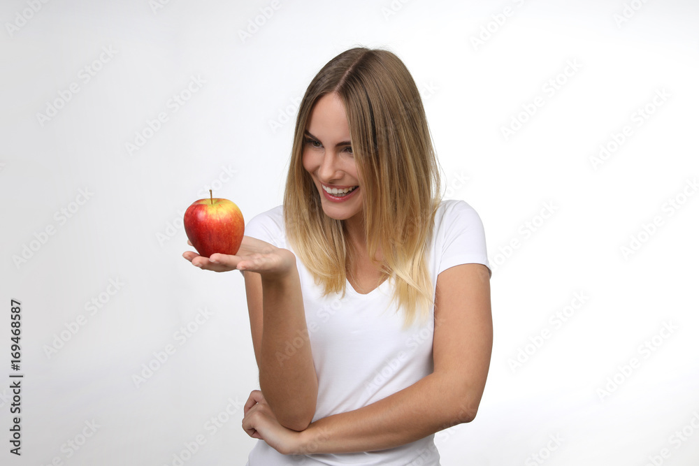 Hübsche blonde Frau mit Apfel lacht Hübsche blonde Frau mit Apfel lacht