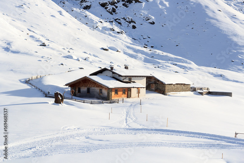 Alpine chalet house and mountain panorama with snow in winter in Stubai Alps, Austria photo