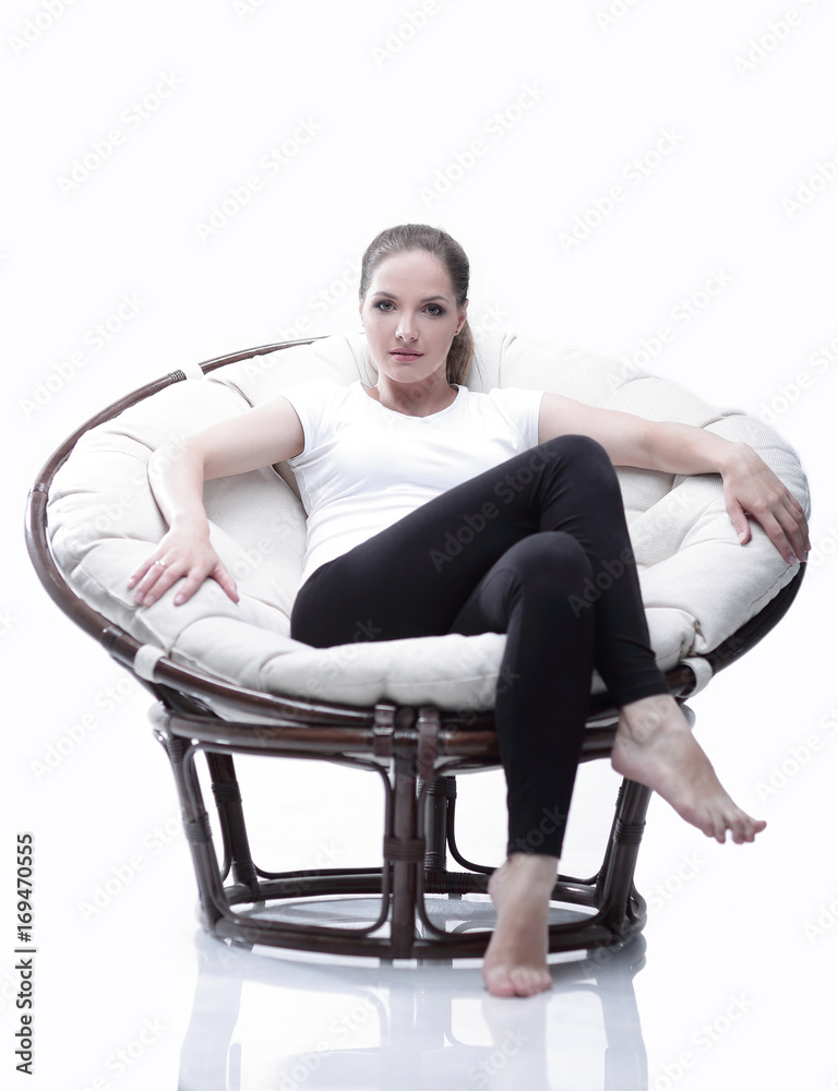 young woman resting in a circular chair with rattan young woman resting in a circular chair with rattan