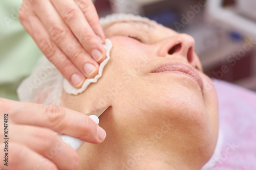 Ultrasonic face cleaning close up. Skin of mature woman.