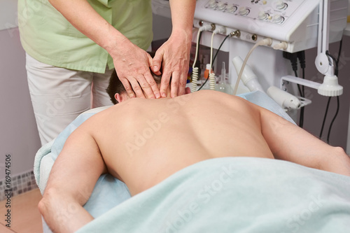 Man having neck massage. Hands of female massage therapist. Non surgical spine treatment.