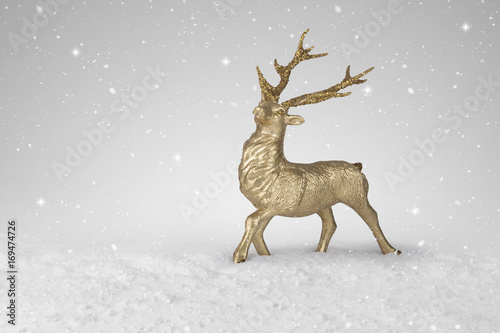 Snow falling on a gold Christmas Reindeer