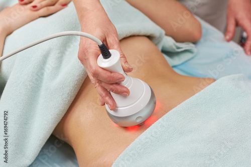 Radio frequency skin tightening machine. Belly of a woman, cosmetology. photo