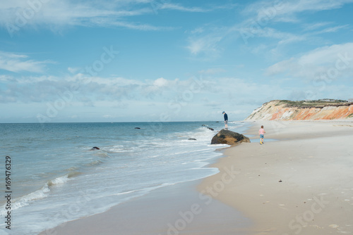 Children climbing on rock by the sea