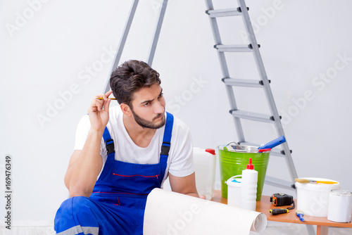 Repairman doing renovation repair in the house with paper wallpa