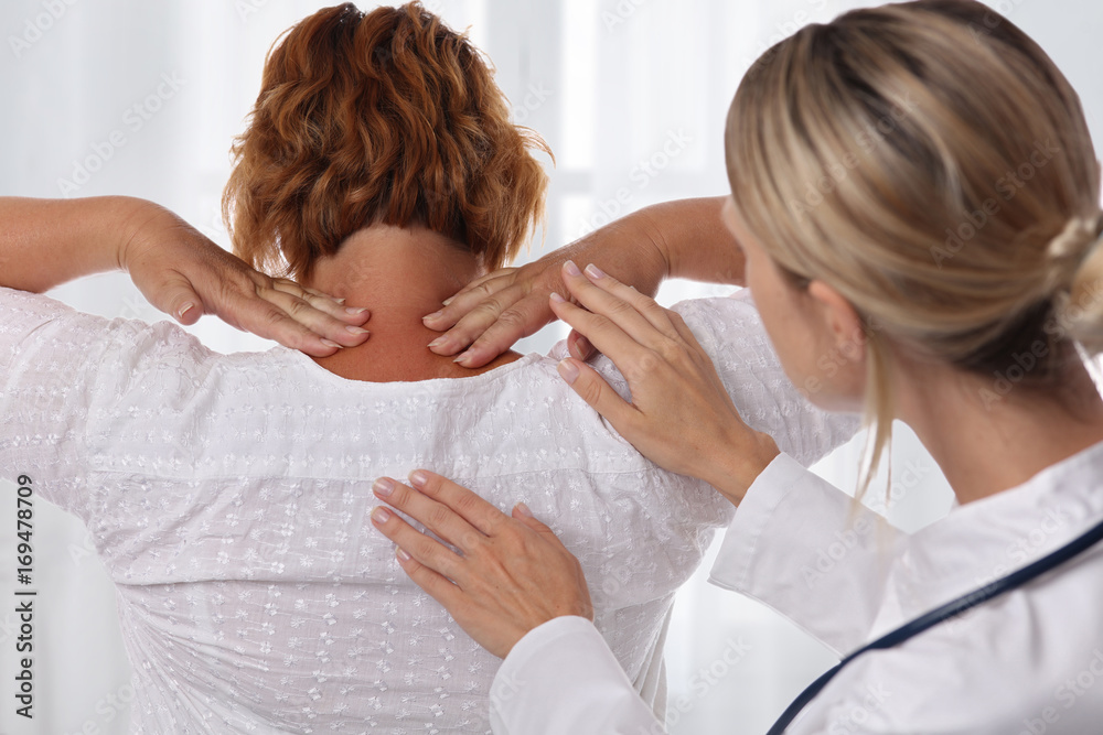 Woman suffering from back pain during medical exam. Chiropractic, osteopathy, Physiotherapy. Alternative medicine, pain relief concept. Woman suffering from back pain during medical exam. Chiropractic, osteopathy, Physiotherapy. Alternative medicine, pain relief concept.