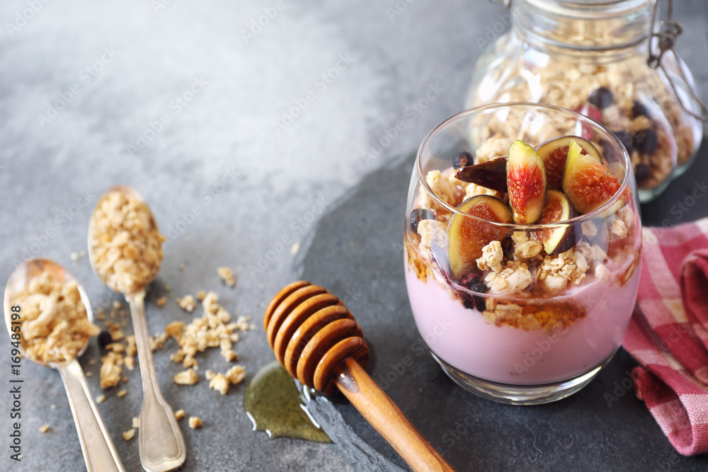 Two glasses of fruit yogurt with granola, figs and honey Two glasses of fruit yogurt with granola, figs and honey