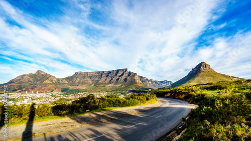 Sun setting over Cape Town, Table Mountain, Devils Peak, Lions Head and the Twelve Apostles. Viewed from the road to Signal Hill at Cape Town, South Africa photo