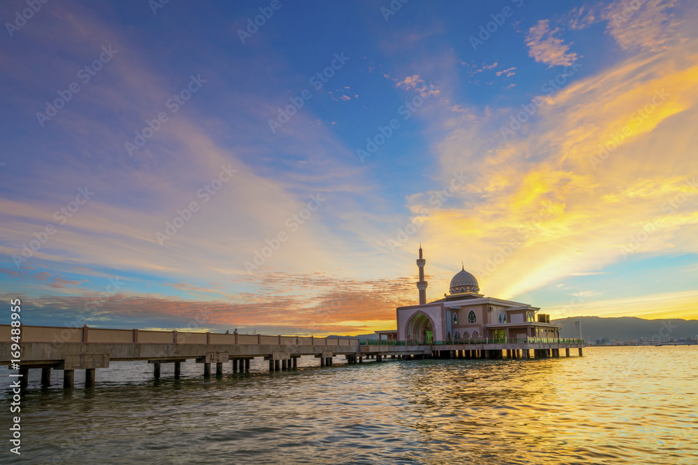 Colorful sunset at a floating mosque by the sea