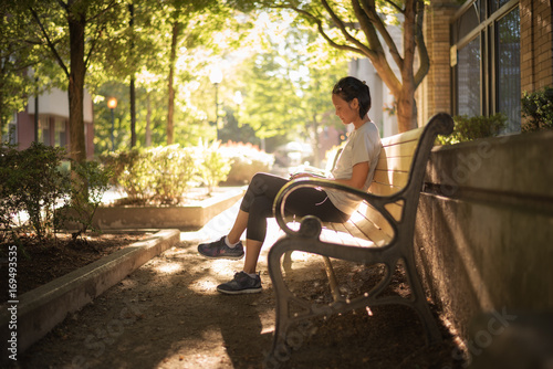 A woman sitting on a city park bench.