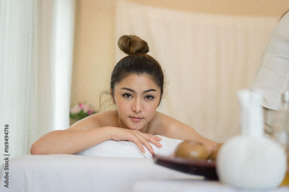 Beautiful smiling woman with flowers resting in the spa before massage. Beautiful smiling woman with flowers resting in the spa before massage.