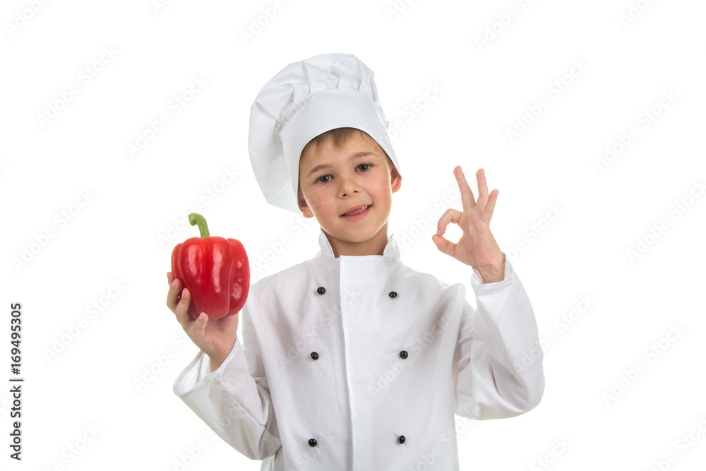 Boy in chef uniform making ok gesture and holding red pepper Boy in chef uniform making ok gesture and holding red pepper