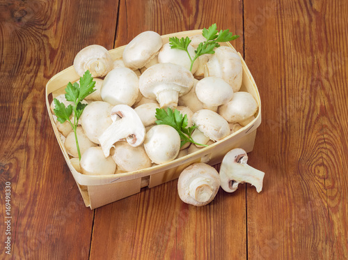 Cultivated button mushrooms in the wooden basket