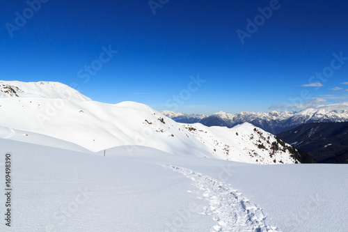 Mountain panorama with snow and snowshoe trail in winter in Stubai Alps, Austria