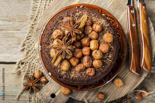 Homemade chocolate crazy cake with chocolate chips, nuts hazelnuts, cinnamon and spices for a cozy autumn tea party. Top View. photo