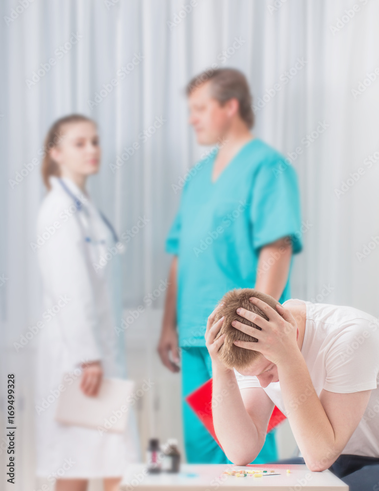 Fototapeta premium Sick man and doctors in the clinic