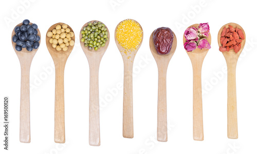 Collection of beans on wooden spoons isolated on white. Black beans, soybeans, mung bean, Chinese date, rose bud, wolfberry and corn Meal Grits.