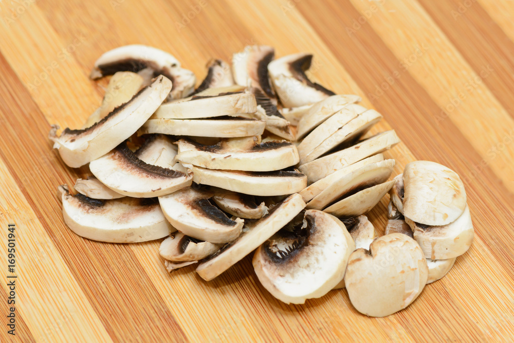 Chopped champignons on a wooden cutting board Chopped champignons on a wooden cutting board
