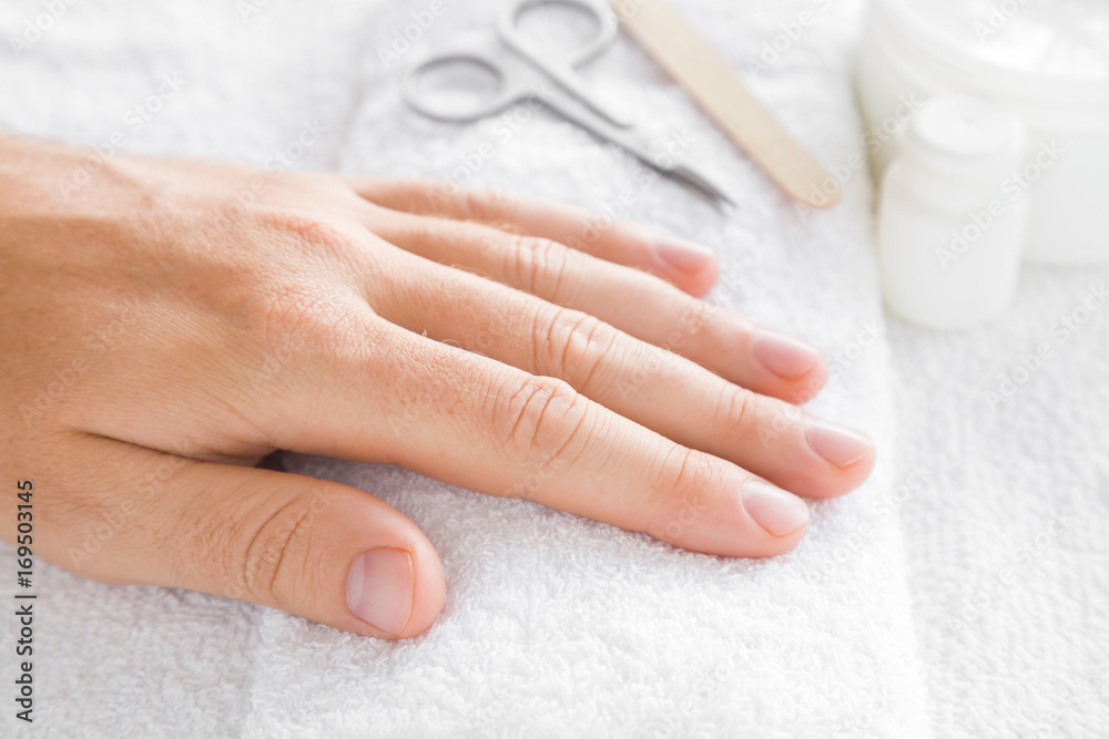 Cares about a man's hands nails. Manicure beauty salon. Scissors and nails file on the white towel. Cares about a man's hands nails. Manicure beauty salon. Scissors and nails file on the white towel.