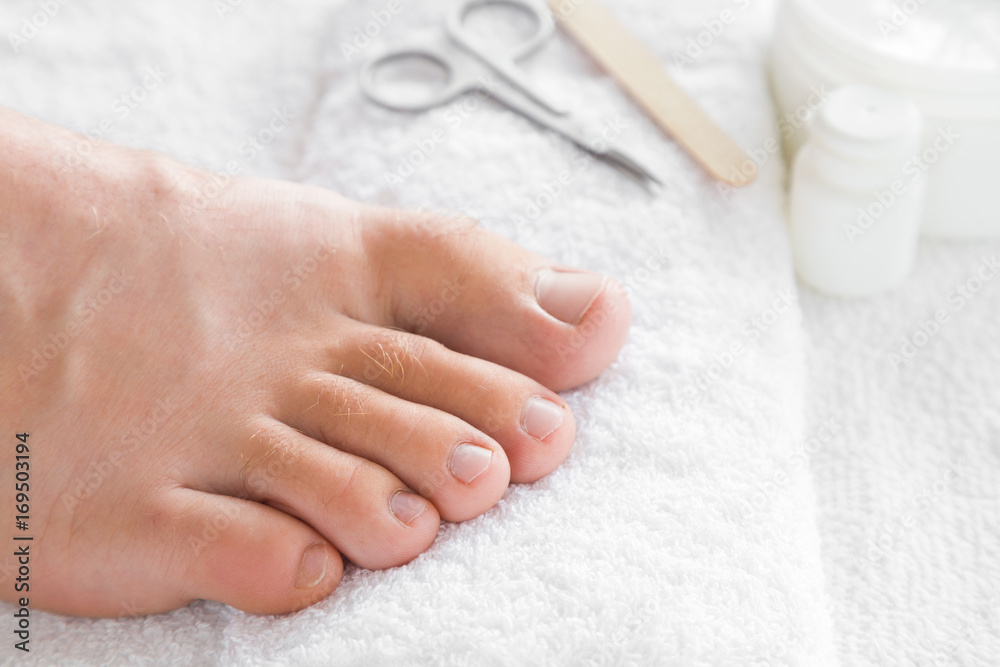 Cares about men's feet nails. Pedicure, manicure beauty salon concept.  Scissors and nail file on the white towel. Stock Photo | Adobe Stock