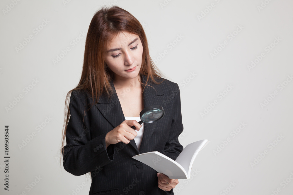 Asian woman with a book and magnifying glass. Asian woman with a book and magnifying glass.