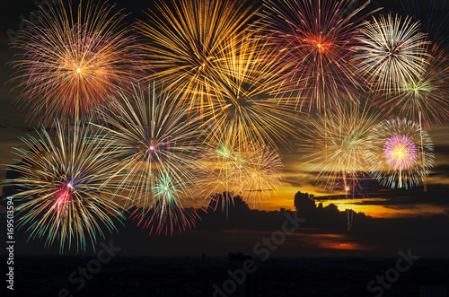 Fantastic festive new years colorful fireworks on the evening sky with majestic clouds