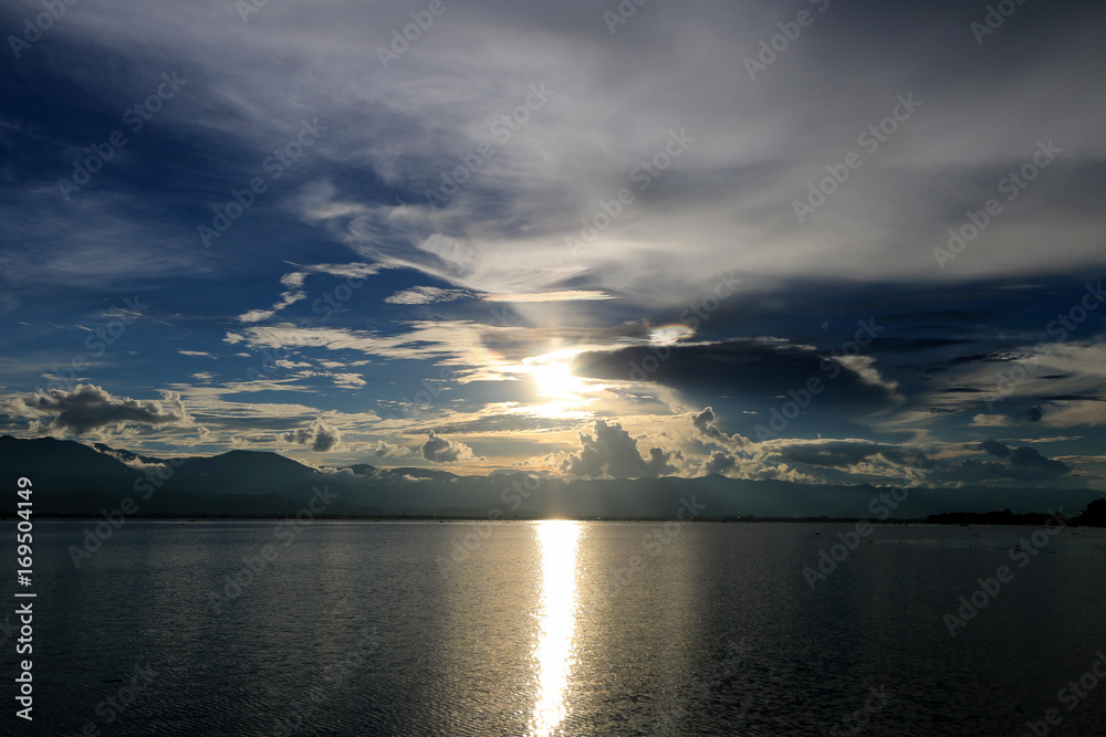 Beautiful sunset and evening sky with mountain and clouds and sunset reflected in the lake for background. Countryside Landscape Under Scenic Colorful Sky At Sunset Dawn Sunrise. Beautiful sunset and evening sky with mountain and clouds and sunset reflected in the lake for background. Countryside Landscape Under Scenic Colorful Sky At Sunset Dawn Sunrise.