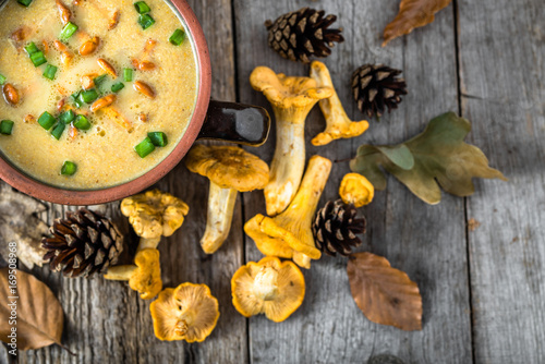 Chanterelle soup and fresh mushrooms on wooden background